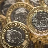 Pound coins sit in a pile