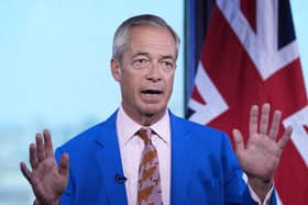 Nigel Farage holding his hands up