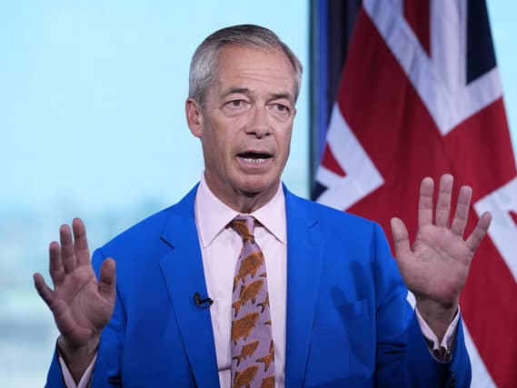 Nigel Farage holding his hands up