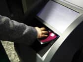 A hand holding a passport onto a scanner at an e-gate
