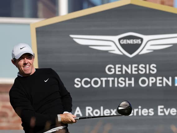 Rory McIlroy tees off in front of a Genesis Scottish Open sign