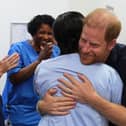 Harry hugs a nurse, with other medical staff clapping nearby