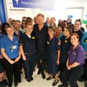 The Duke of Sussex poses for a photo with medical staff