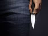 A model poses holding a knife.