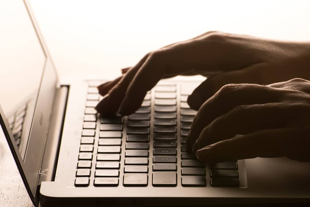 A woman’s hands on a laptop keyboard.