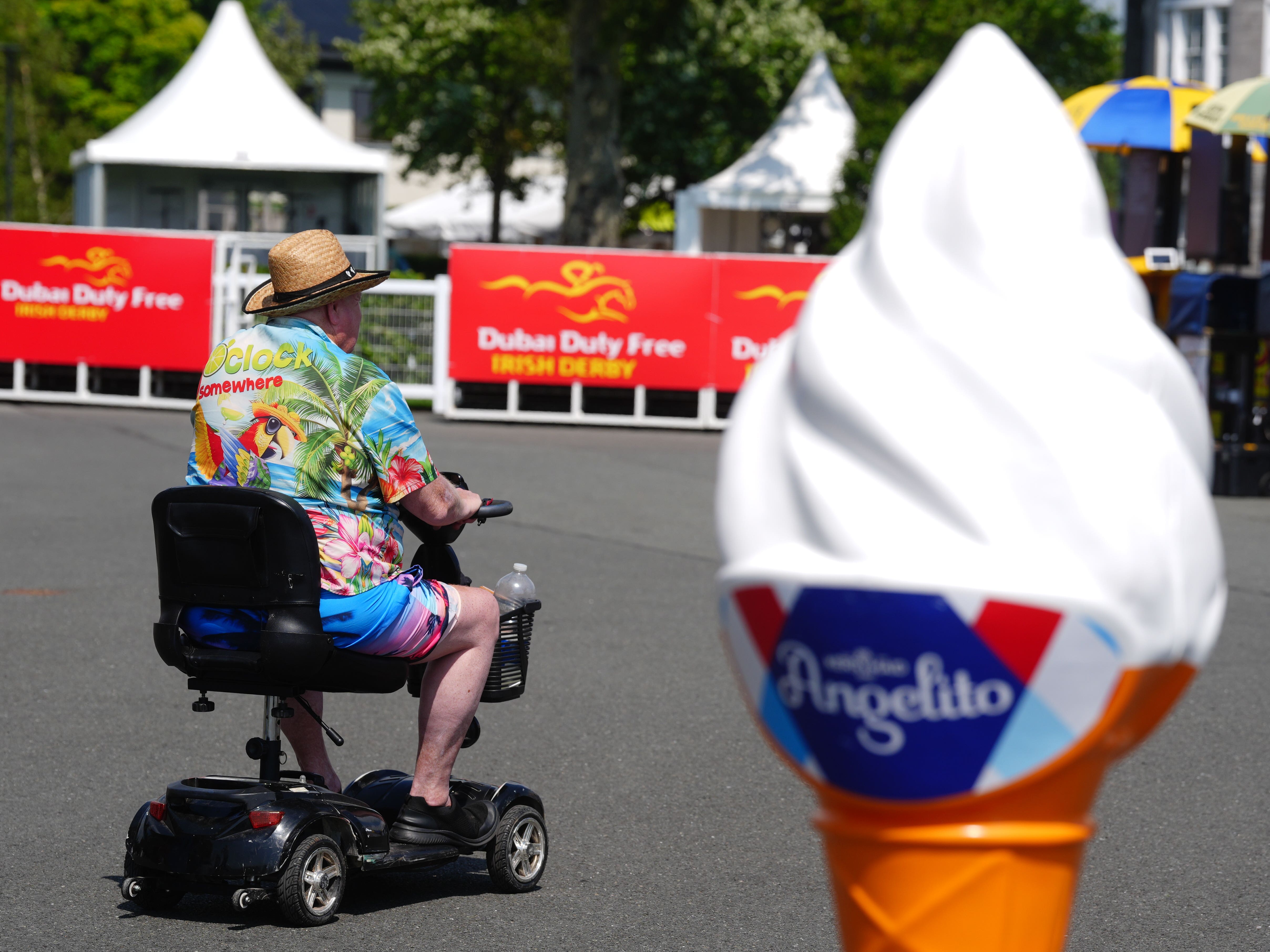 A racegoer passes by an ice cream advertising cone at the Curragh Racecourse in Curragh in Co Kildare