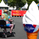 A racegoer passes by an ice cream advertising cone at the Curragh Racecourse in Curragh in Co Kildare