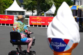 A racegoer passes by an ice cream advertising cone at the Curragh Racecourse in Curragh in Co Kildare