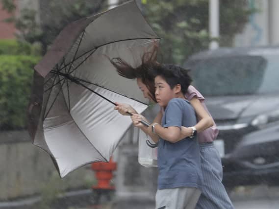 People struggle with an umbrella