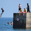 A boy jumping off a sea wall into the sea