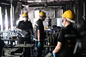 Officers inspect the site of the fire