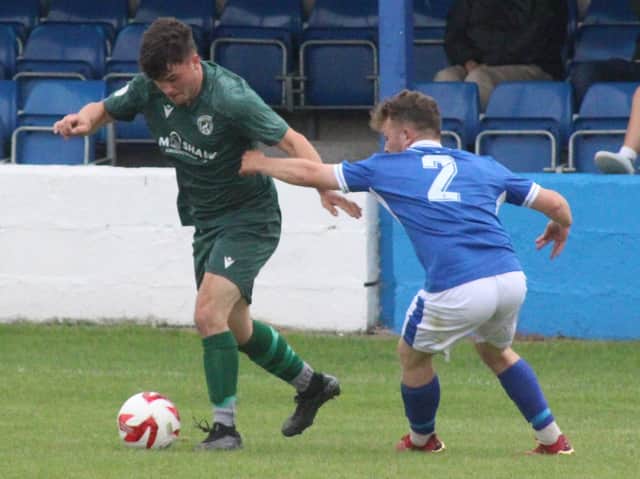 Jack Clarke (green shirt) of Radnor valley and Gavin Rowlands of Llandrindod Wells compete for the ball in their Lock Stock Ardal North East derby on The Broadway