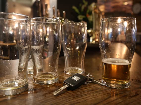 Beer glasses and a set of car keys on a bar in a pub