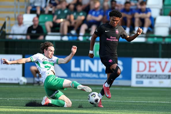 Dan Williams of The New Saints FC clears the ball from Aaron Malouda of Sabah FK