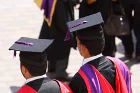 The backs of students in graduation hats and gowns