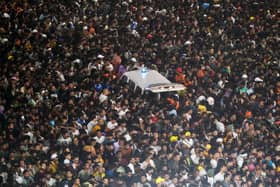 An ambulance is surrounded by pilgrims