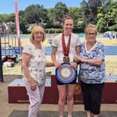 Jimmy Moore Memorial Plate presented by Jimmy's wife to Sally Wildig - the first female runner from Much Wenlock. Sally is seen here also wearing the medals she won in two of the race categories.