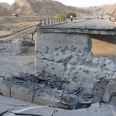 People on a bridge destroyed after a strike in Hormozgan province