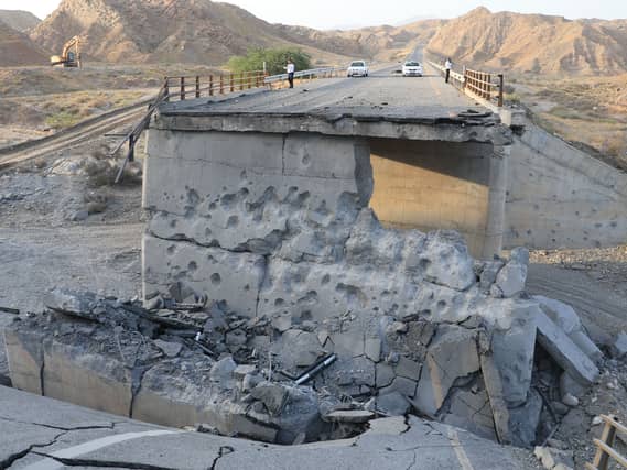People on a bridge destroyed after a strike in Hormozgan province