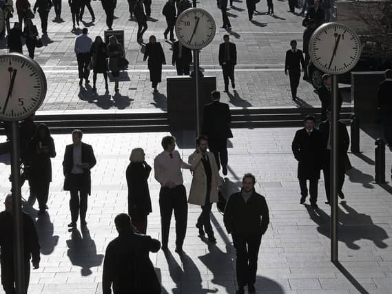 Shadows and silhouettes of pedestrians walking through Reuters Plaza, Canary Wharf, London, UK