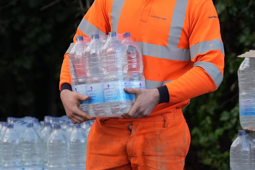A worker hands out bottled water at the Tunbridge Wells Sports Centre