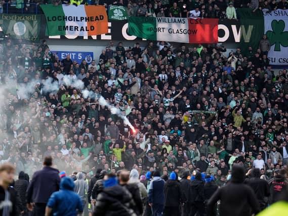 A firework is launched between Celtic and Rangers fans
