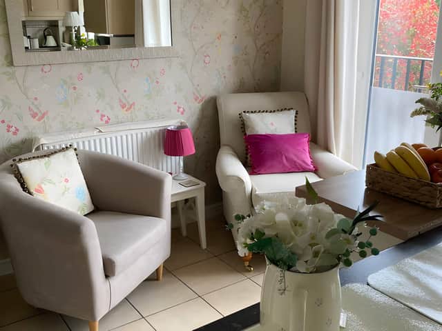 The bright sitting room enjoys attractive views across the established rear garden and woodland beyond.