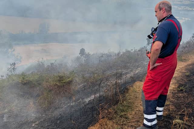 A firefighter surveys the fire on Hanter Hill with charred earth clearly visible