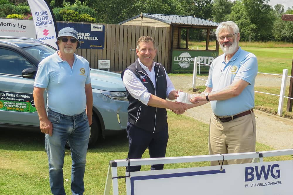 Builth Wells Rotarians, John Price and David England receiving a cheque from Tim Evans of Builth Wells Garages, on behalf of himself and brother Martyn.