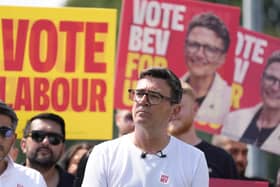 Andy Burnham with vote Labour and vote Bev placards behind him