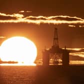 Oil platform with sun rising in background