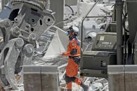 A firefighter searches a damaged shopping centre following an explosion triggered by an earthquake in Kashima, southern Japan