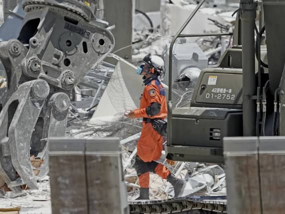 A firefighter searches a damaged shopping centre following an explosion triggered by an earthquake in Kashima, southern Japan