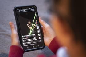 A young girl using social media app TikTok on a mobile phone