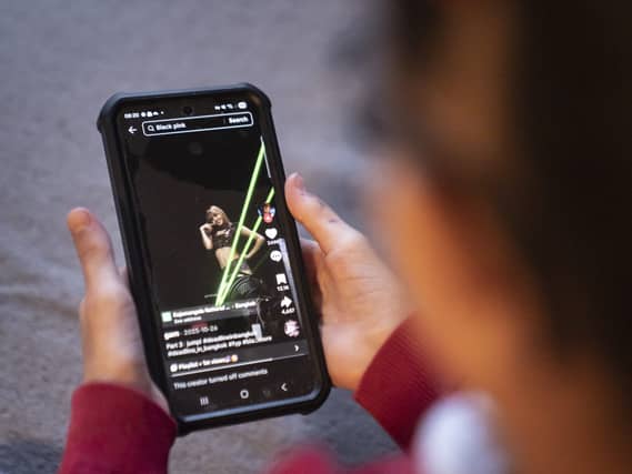 A young girl using social media app TikTok on a mobile phone