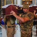 Soldiers carry a coffin