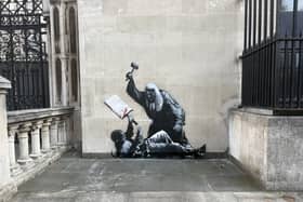 An artwork by Banksy at the Royal Courts of Justice in London which shows a judge attacking a protester with a gavel