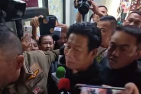 Chalong Riewraeng, centre, a former local Thai legislator, walks past media members in Nonthaburi, Thailand