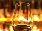 A dram of whisky in front of amber lighting