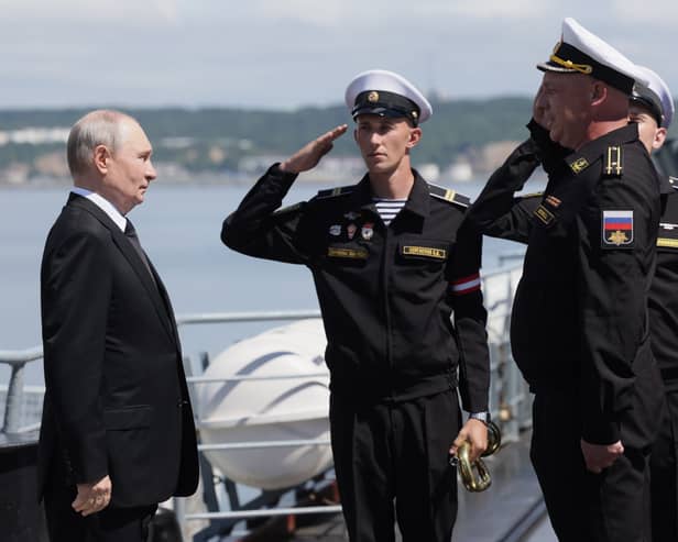 Russian President Vladimir Putin, left, visits a missile cruiser of the Pacific Fleet to watch a military exercise on Sakhalin Island, Russia Russian President Vladimir Putin, left, visits a missile cruiser of the Pacific Fleet to watch a military exercise on Sakhalin Island, Russia