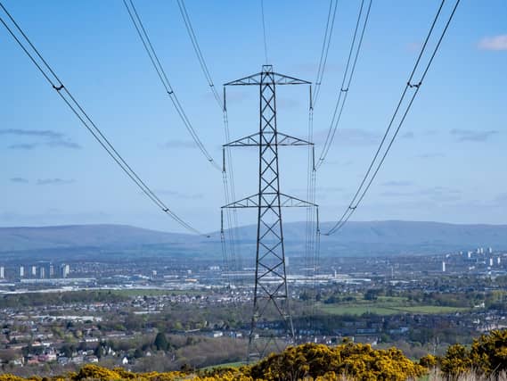 View of pylons across a landscape, with a residential area nearby