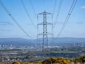 View of pylons across a landscape, with a residential area nearby