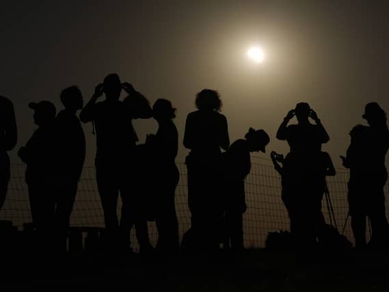 People watching the solar eclipse near Stonehenge in Wiltshire