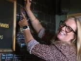 Grace McLaughlin smiling while signing her name on a board