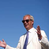 Nigel Farage wearing sunglasses with his hands held apart