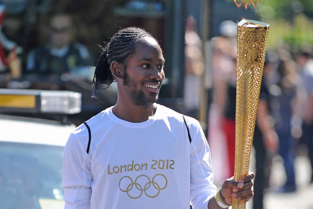 Jason Arday carries the Olympic flame