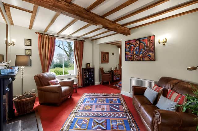 High ceilings, large windows, fireplaces and exposed beams bring period character to the home's reception spaces