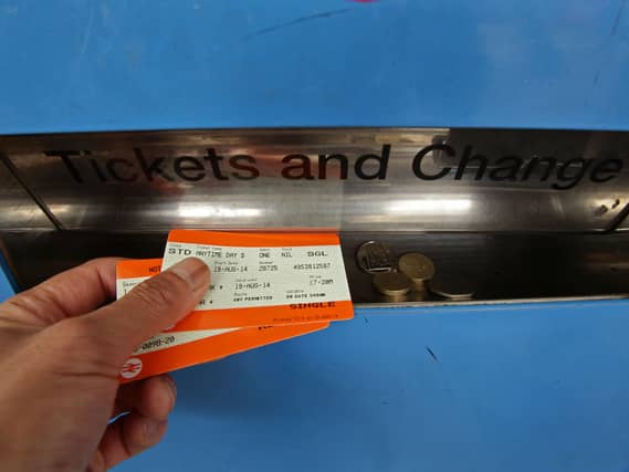 A man collecting train tickets from a machine at Finsbury Park station in north London