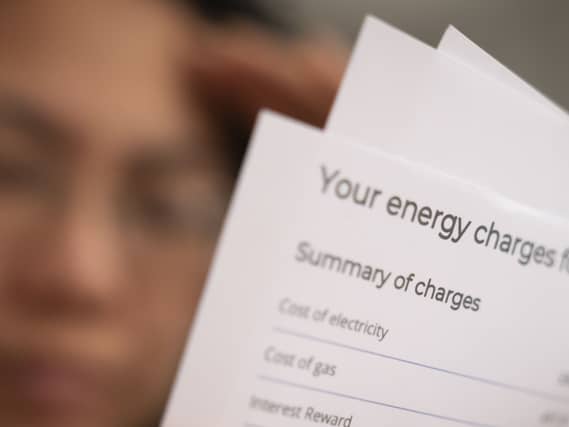 A person holding an energy bill.