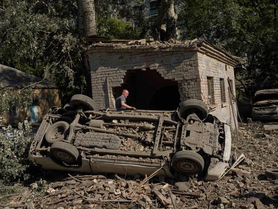 A local resident stands next to destroyed cars after an overnight Russian attack on Kyiv, Ukraine